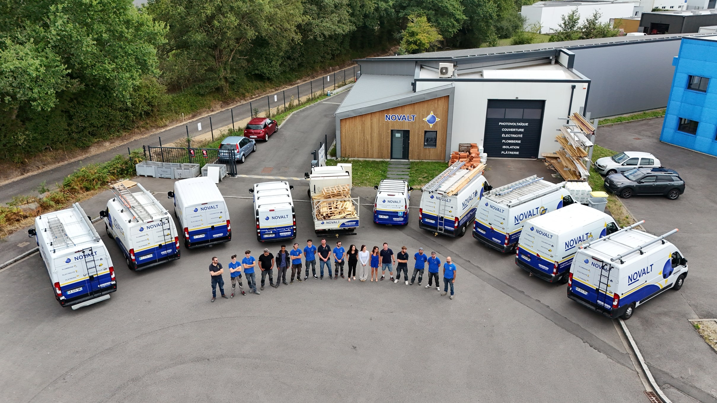 L'équipe NOVALT Couverture devant le siège social à Bouaye avec la flotte de véhicules